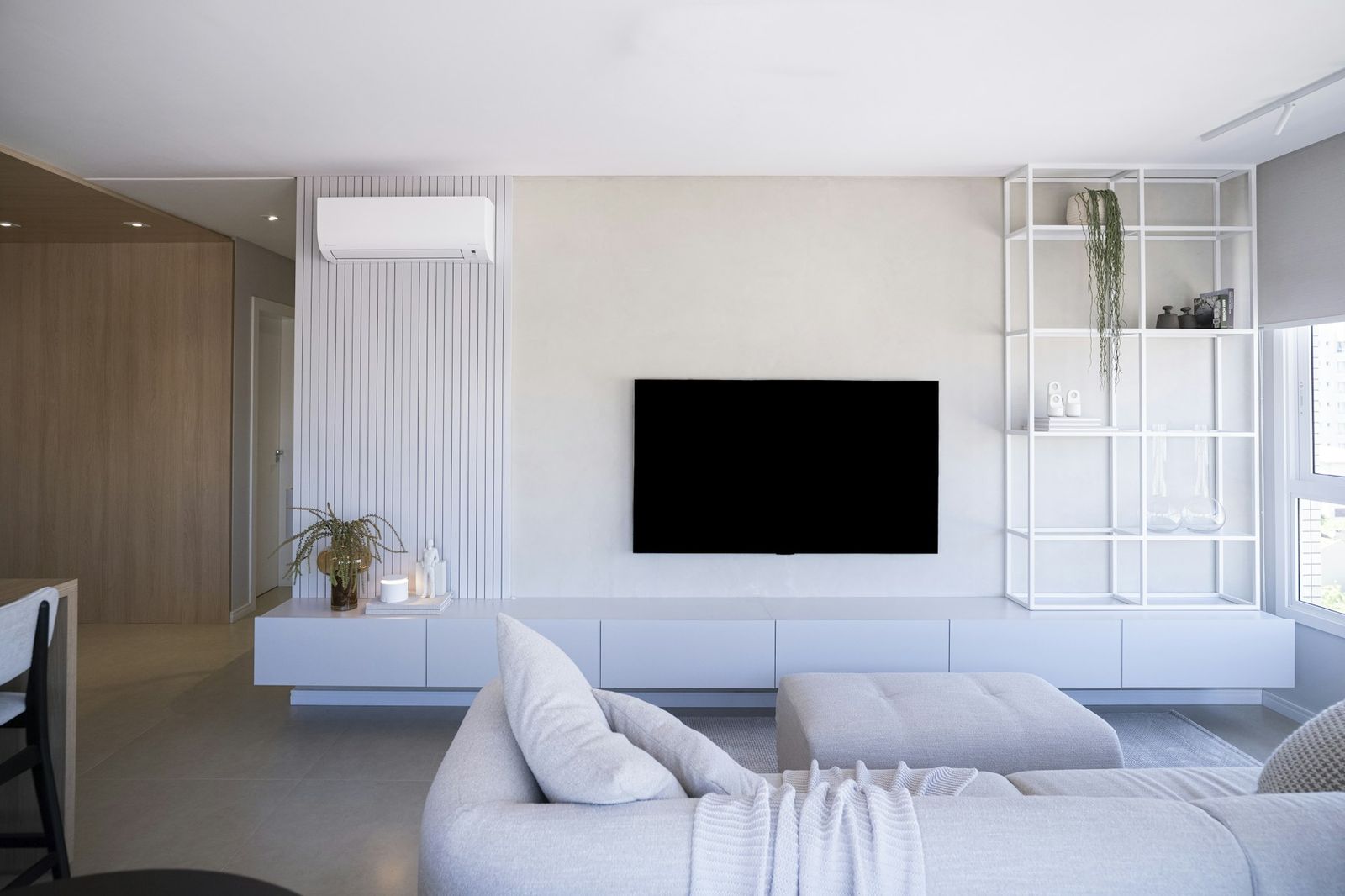 A white living room with a wall-mounted air conditioning unit